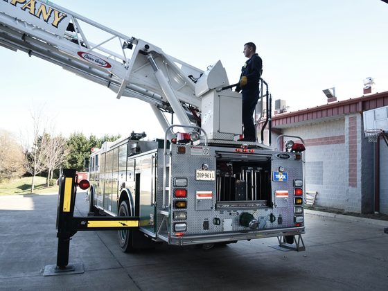 An aerial ladder truck outside a fire station